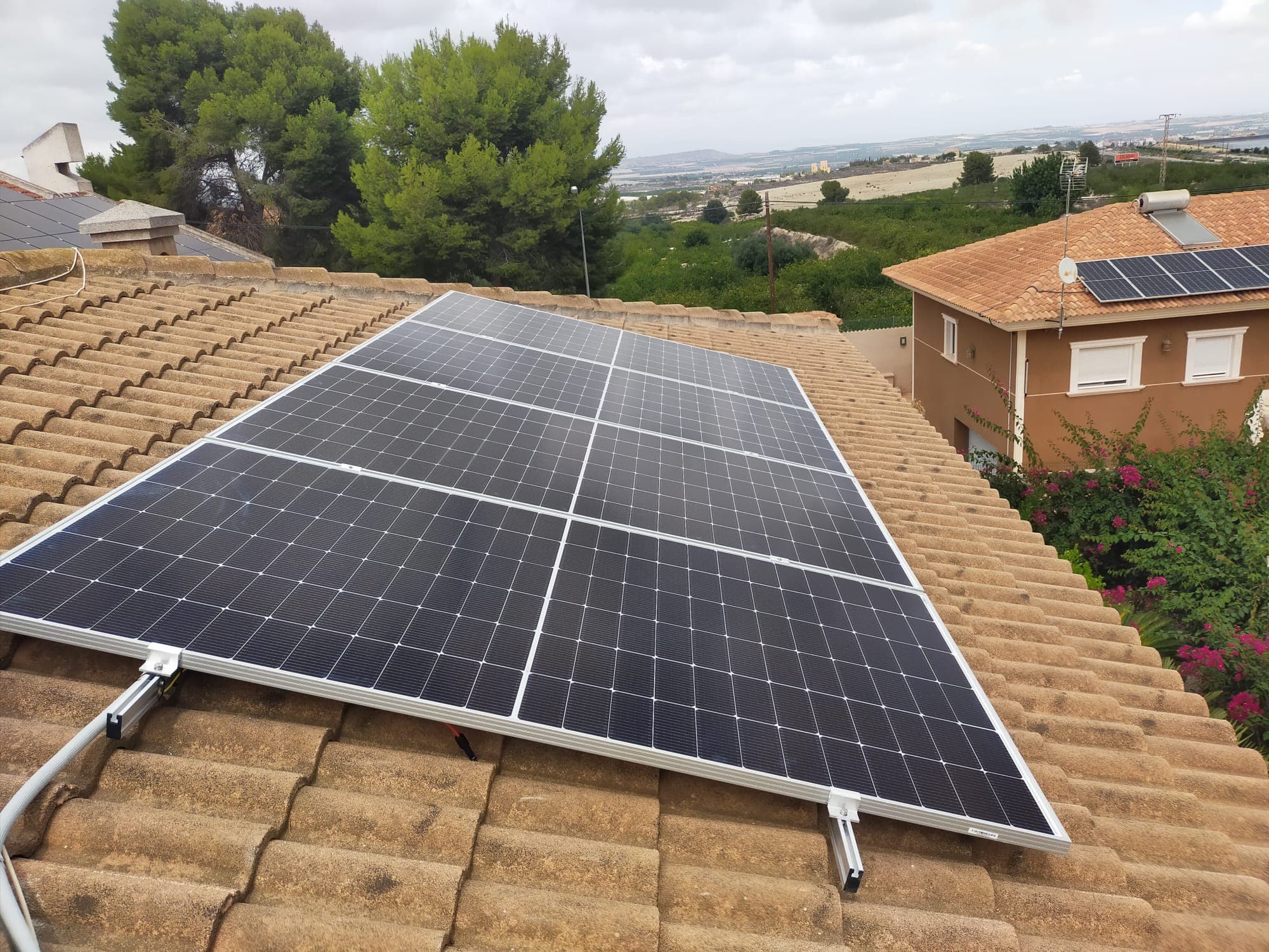 Solar panels on a tiled roof with the town behind