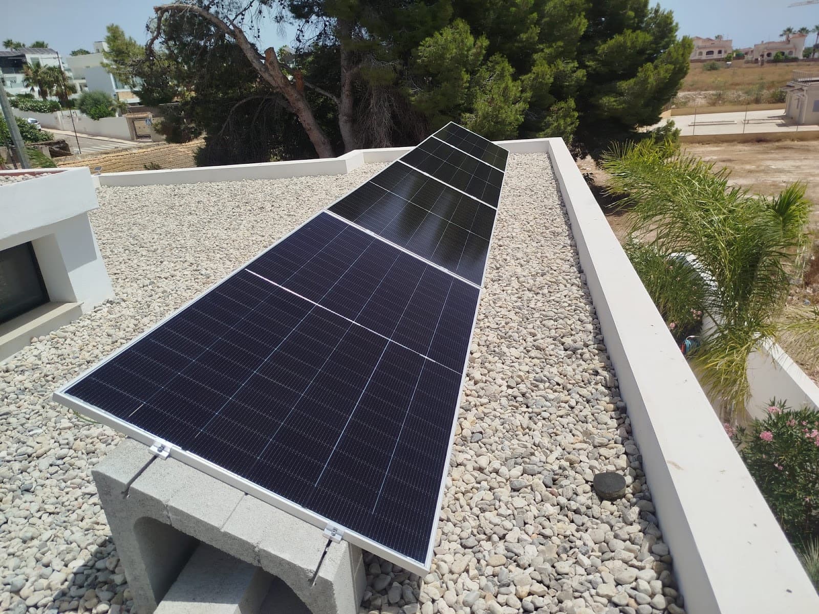 Solar panels on frames on a flat gravel roof, installed by Sunrise Energy