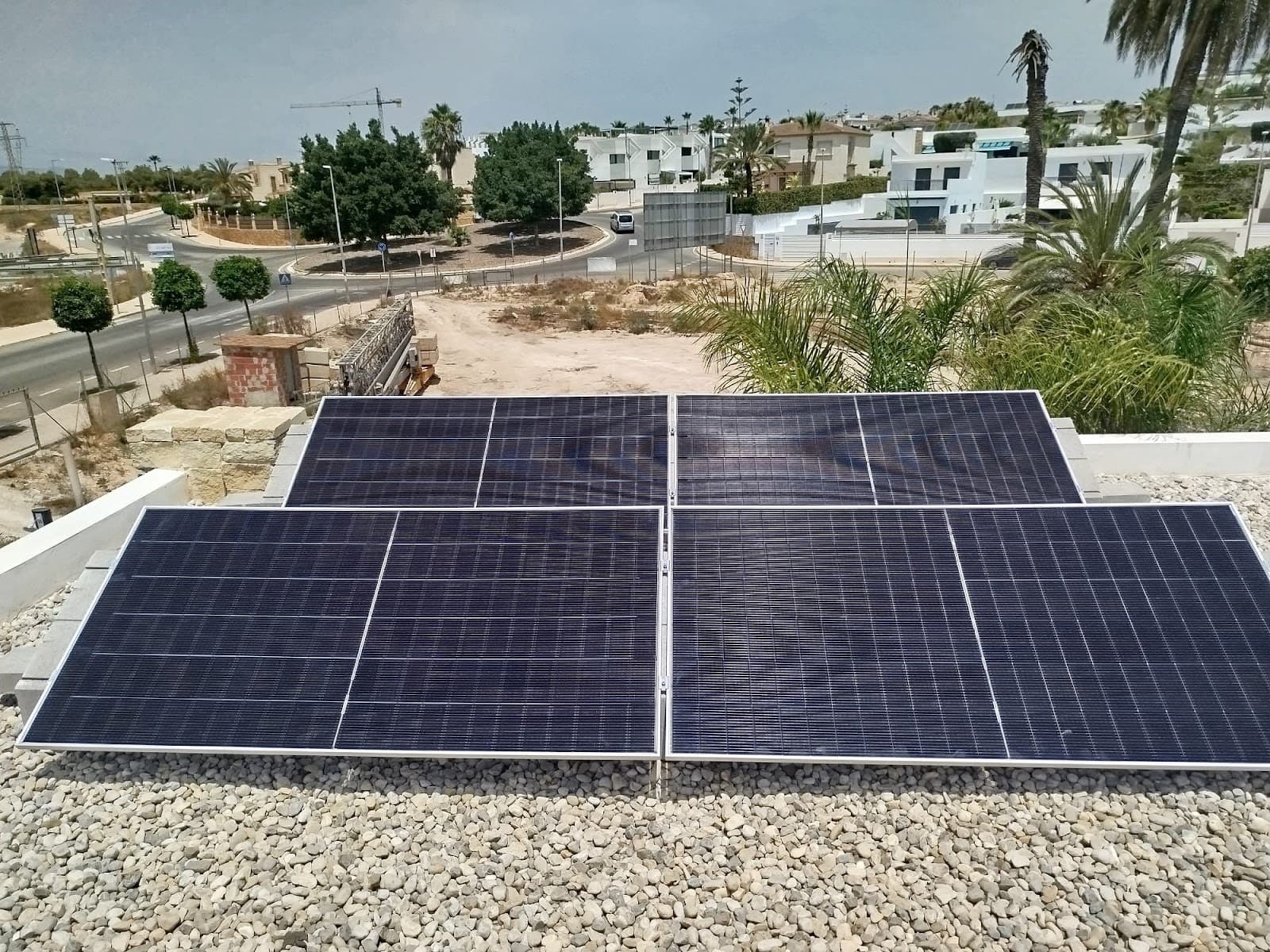 Solar panels on frames on a flat gravel roof, installed by Sunrise Energy