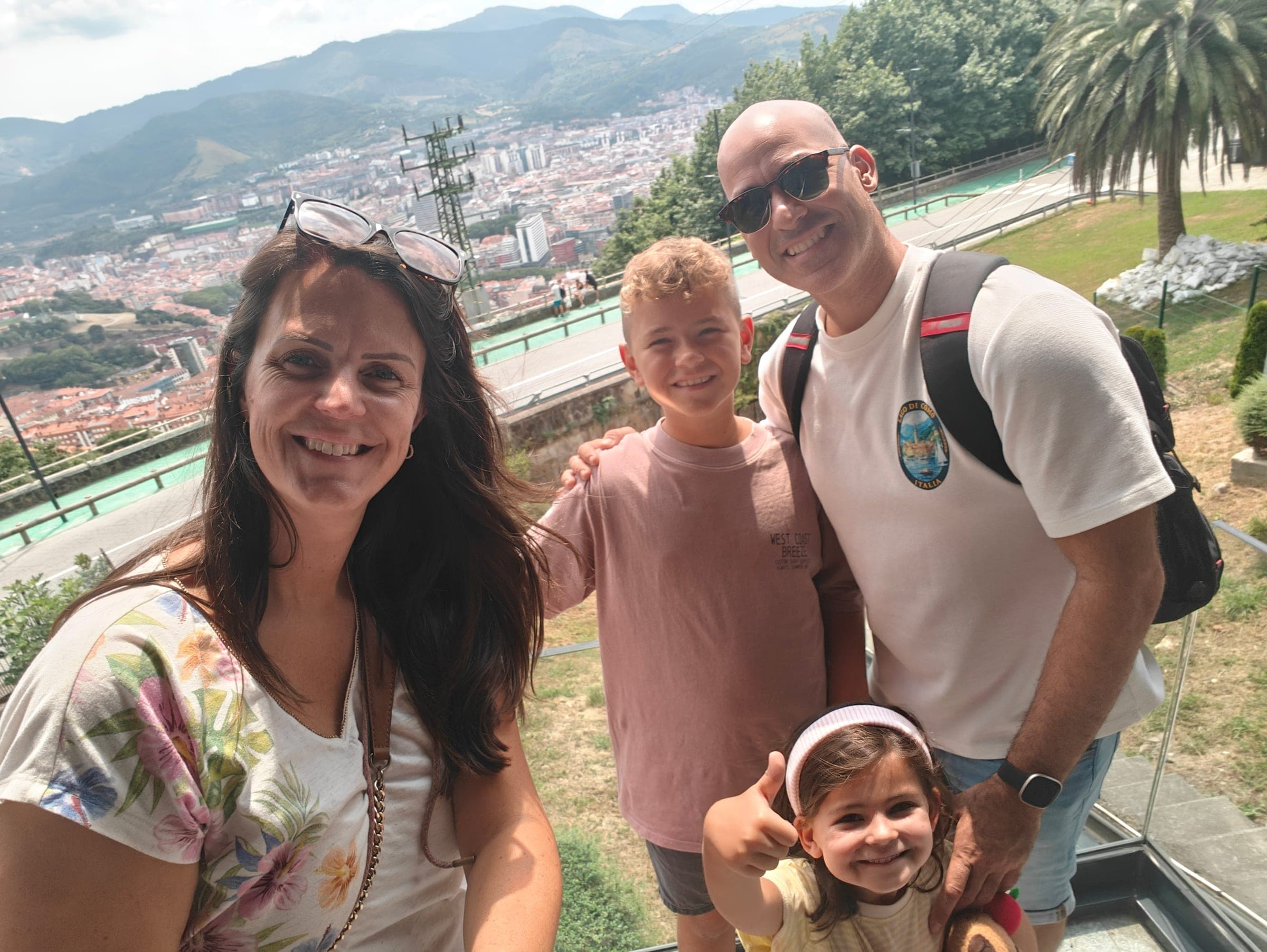 Joëlle y José de Sunrise Energy con sus dos hijos, al aire libre en un mirador sobre una ciudad